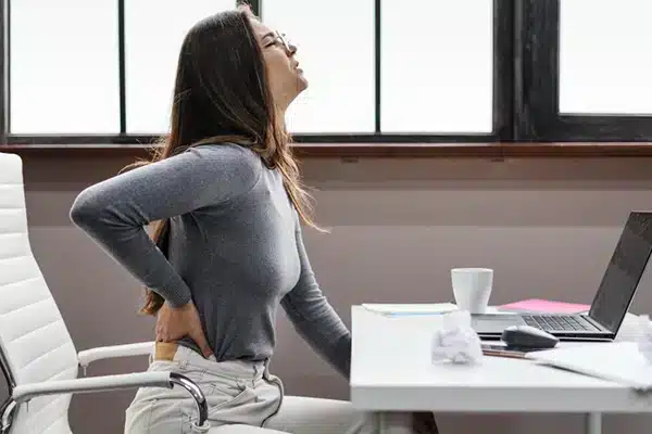 side view woman having a backache while working from home