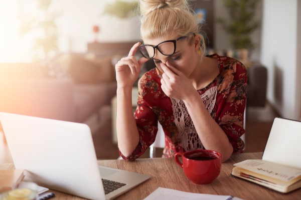 Stressed busy woman with headache working from home